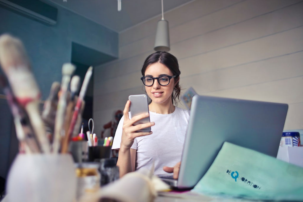 Employee smiling at phone in office, potential gift recipient.