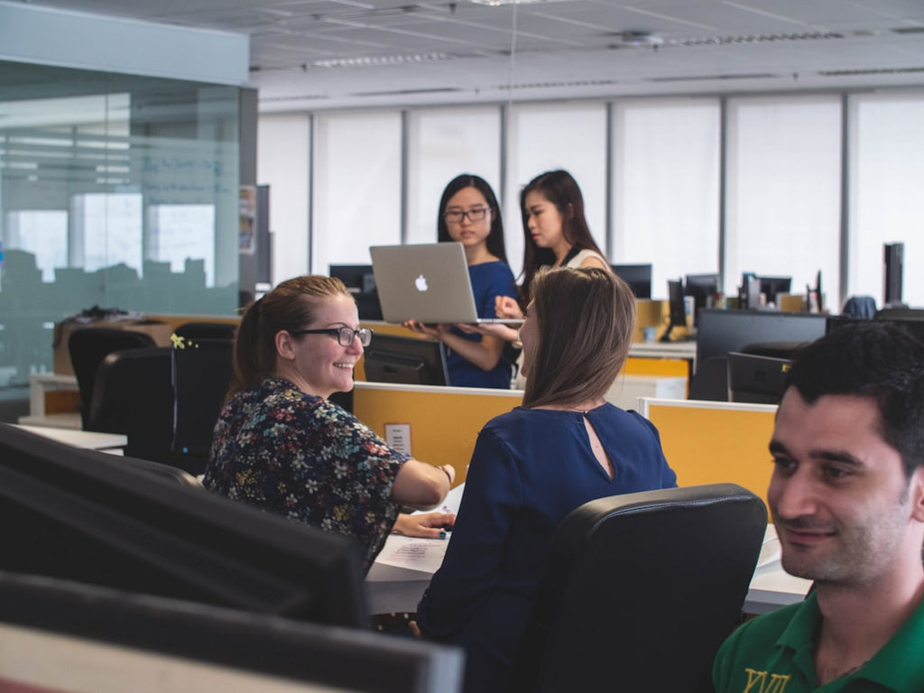 "Employees interacting happily in an office setting"